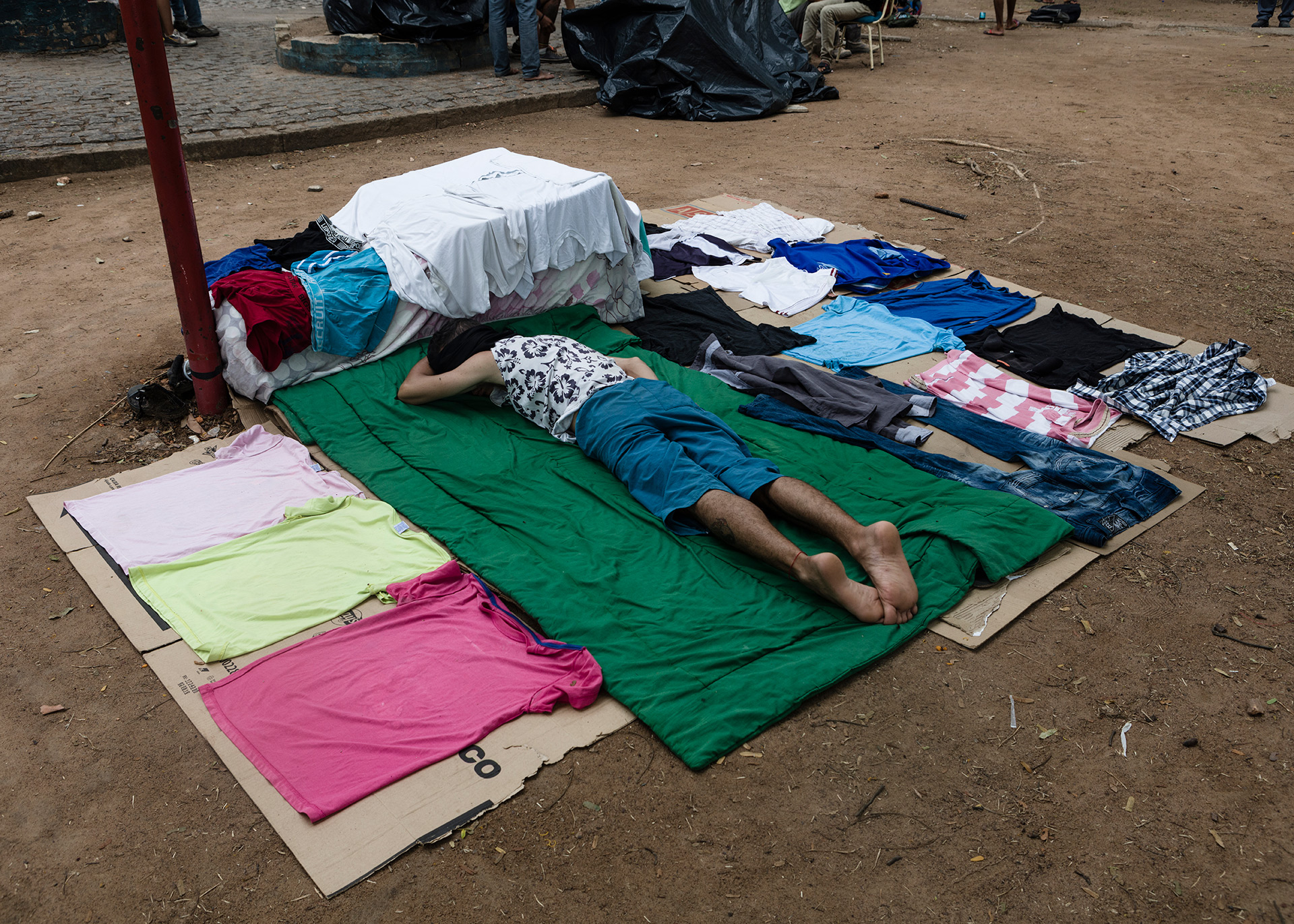 A man rests over the floore while waiting to be accepted in a local shelter, 2018.