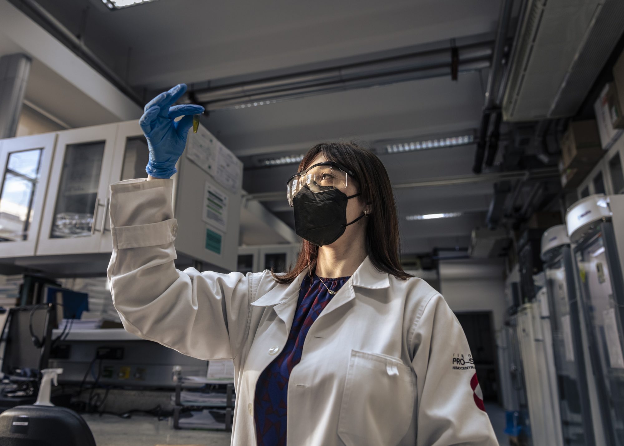 Portrait of the São Paulo University Medical 
investigation laboratory's researcher Ana Carolina Soares de Oliveira observing a blood plasma sample.